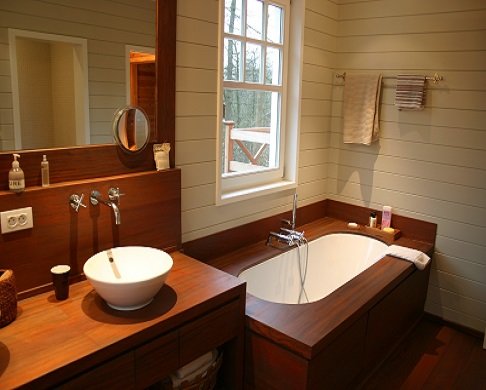 Salle de bain en bois avec vasque à poser et baignoire habillée